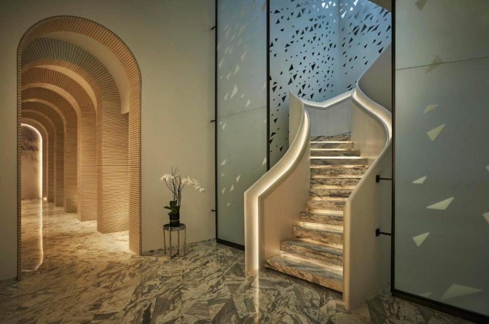 Escalier moderne avec éclairage intégré dans un intérieur élégant, marbre et décoration minimaliste. Parfait pour une ambiance sophistiquée et accueillante, idéale pour des escapades de rêve.