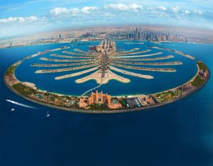 Dubai Palm Jumeirah vue aérienne avec ses îles en forme de palmier et la ville moderne en arrière-plan. Une destination de rêve pour des vacances luxueuses et inoubliables.