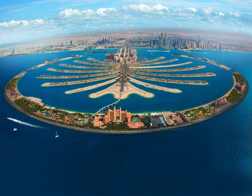 Dubai Palm Jumeirah vue aérienne avec ses îles en forme de palmier et la ville moderne en arrière-plan. Une destination de rêve pour des vacances luxueuses et inoubliables.